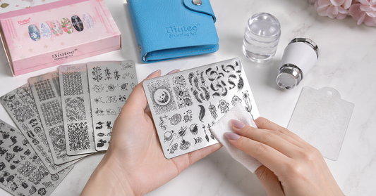 BIUTEE nail stamping plates being cleaned with a lint-free wipe beside the real stamping kit