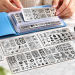 BIUTEE metal nail stamping plates, clear stamper, scraper and storage pouch arranged on a manicure desk.